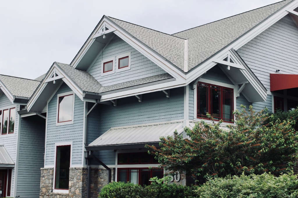 Blue craftsman-style home with a gray asphalt shingle roof