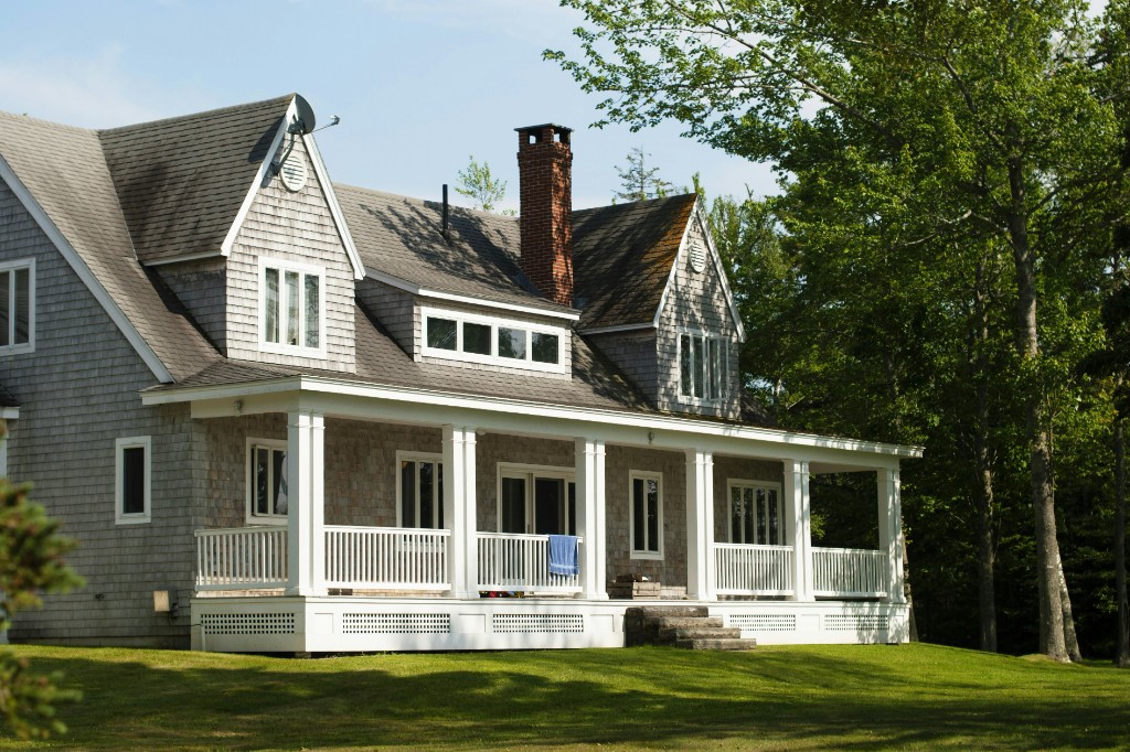 Gray-shingled home with a wraparound porch and a new roof