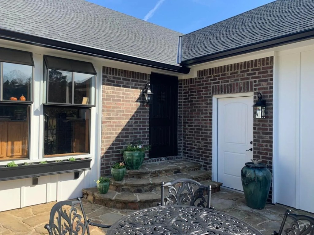 Light blue siding with large windows during renovation