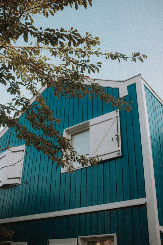 Freshly painted teal home exterior with white trim and shutters