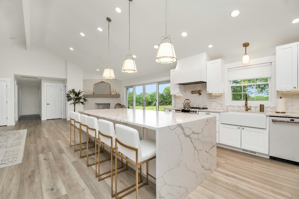 Newly remodeled open-concept kitchen with a large marble island and pendant lighting